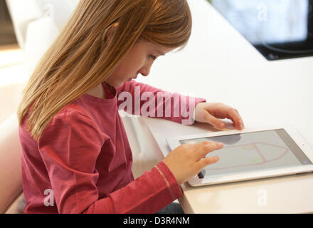 Jeune fille jouant sur un Apple iPad tablet computer Banque D'Images
