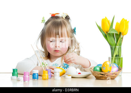 Baby Girl painting Easter eggs isolé sur fond blanc Banque D'Images