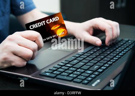 Man holding colorful carte de crédit. Les mains sur un clavier d'ordinateur Banque D'Images