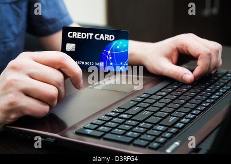 Man holding colorful carte de crédit. Les mains sur un clavier d'ordinateur Banque D'Images