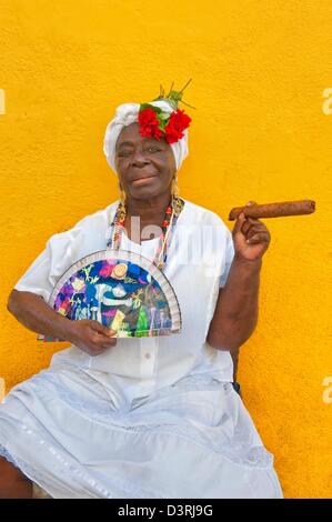 La femme cubaine origine africaine Santeria traditionnelles robe blanche présente dans la vieille Havane avec cigar & fan de pair La Havane Cuba Banque D'Images