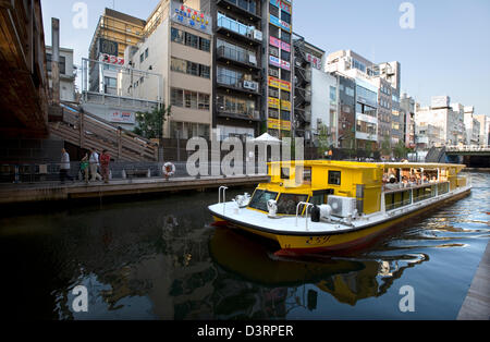 Bateau touristique croisière sur la Rivière Dotonbori dans le centre de Osaka Namba du quartier commerçant. Banque D'Images