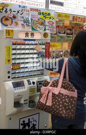 Un client choisit un repas à partir d'un distributeur alimentaire japonais à un restaurant fast-food. Banque D'Images