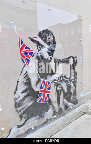 La nouvelle oeuvre de graffiti Banksy '' montrant un garçon avec une machine à faire de l'ensemencement Union Jack noir sur le mur de l'Poundland Banque D'Images