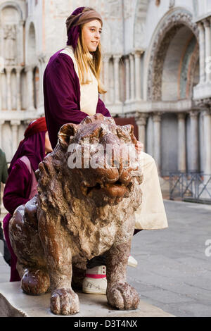 Girl assis sur un Lion en bronze doré à la place Saint Marc Venise Italie Banque D'Images