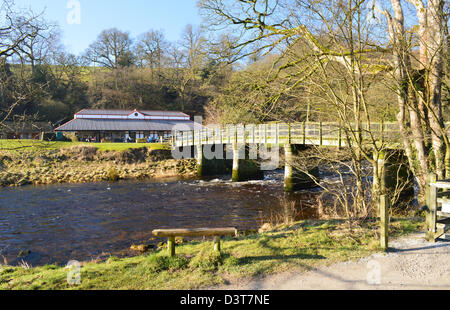 Banc en bois & Passerelle par la rivière Wharfe près du pavillon de Cavendish sur le Dales Way Sentier Yorkshire Banque D'Images