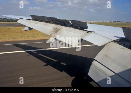 Aile d'un avion à l'atterrissage sur une piste de l'aéroport Banque D'Images