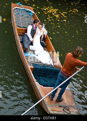 Asian Bride and Groom dans un punt sur la rivière Cam Cambridge Cambridgeshire Angleterre Le dos Europe Banque D'Images