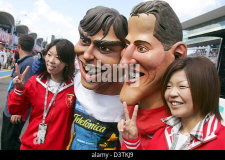 Formule 1 fans japonais posent avec caricature de F1 pilotes allemand Michael Schumacher (R) et l'Espagnol Fernando Alonso avant le Grand Prix du Japon à l'hippodrome à Suzuka, au Japon, le dimanche 08 octobre 2006. Photo : Gero Breloer Banque D'Images