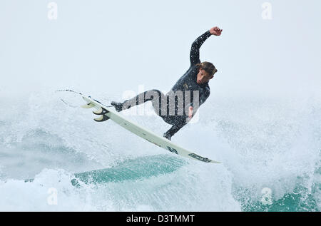 Surfer mid air jump, St Agnes, Cornwall, UK Banque D'Images