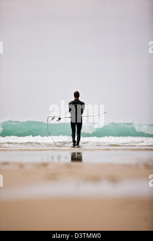 Surfer est à la mer, à St Agnes, Cornwall, UK Banque D'Images
