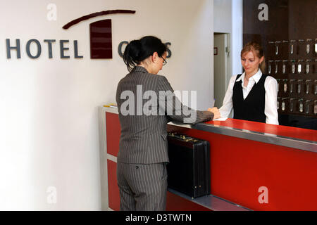 Une jeune femme remplit un formulaire d'inscription pour sa chambre d'hôtel à la réception de l'Hotel Gates à Berlin, Allemagne, mercredi, 13 juin 2006. Photo : Gero Breloer Banque D'Images