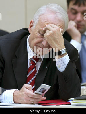 Le Premier Ministre bavarois Edmund Stoiber regarde son téléphone portable dans la salle plénière du Parlement (Landtag) de Bavière à Munich, Allemagne, le mardi, 12 décembre 2006. Photo : Peter Kneffel Banque D'Images