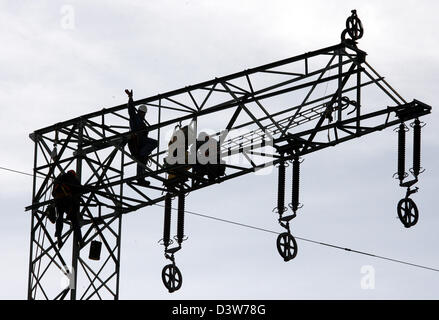 Le personnel de la FBG Freileitungsbau travailler sur un conducteur de 110 kV à Eberswalde, Allemagne, 10 janvier 2007. 46 poteaux d'électricité sont remplacés à l'occasion d'une révision générale. Les fournisseurs d'énergie allemand produisent le pouvoir et contrôle le secteur. La Commission de l'UE a l'intention de forcer le pouvoir de vendre le secteur des producteurs haut afin de pousser les prix plus bas et de concurrence. Photo : Bernd Settnik Banque D'Images