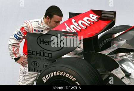 Le pilote de Formule 1 espagnol Fernando Alonso a un oeil à la nouvelle voiture de course de Formule 1 McLaren Mercedes MP4-22 lors d'un photocall à Valence, en Espagne, le lundi 15 janvier 2007. La voiture est d'être pesented officiellement au public dans un spectacle événement plus tard. Photo : McLaren Mercedes Banque D'Images