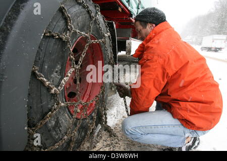 Un chauffeur de camion rassemble des chaînes à neige pour les pneus de son camion sur l'autoroute B31 en Hoellental, Allemagne, mercredi, 24 janvier 2007. De fortes chutes de neige pendant la nuit a créé des situations de trafic chaotique dans les régions du sud de l'Allemagne. Photo : Patrick Seeger Banque D'Images