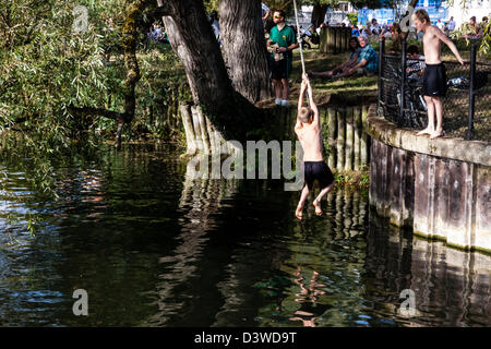 Les jeunes garçons une corde pivoter sur la rivière Cam au bassin, Cambridge, Cambridgeshire, UK Banque D'Images