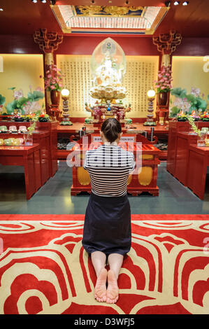 Femme en prière à l'intérieur du temple de la Dent Sacrée, Singapore, Asia Banque D'Images