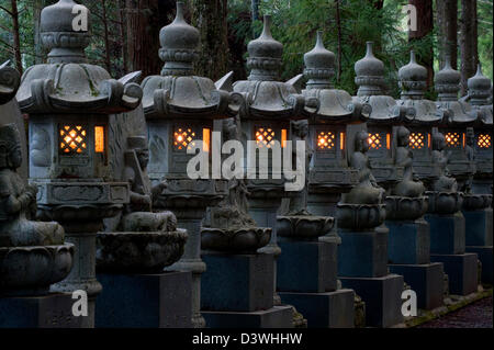 Rangée de courts de lanternes en pierre avec des statues de Bouddha en entre au Temple Okunoin cemetery sur Koyasan (Mont Koya), Wakayama Banque D'Images