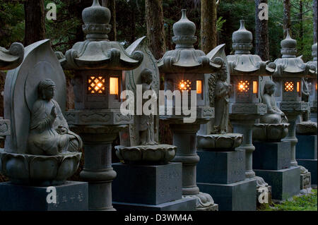 Rangée de courts de lanternes en pierre avec des statues de Bouddha en entre au Temple Okunoin cemetery sur Koyasan (Mont Koya), Wakayama Banque D'Images