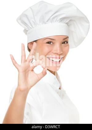 Portrait de race mixte femme cuisinière portant chapeau de chef montrant OK part signer la perfection isolé sur fond blanc Banque D'Images