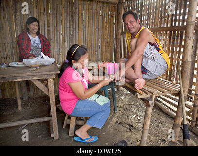 L'homme reçoit une manucure dans un salon de cabane en bambou dans les Philippines. Banque D'Images