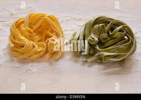 Vue rapprochée de la main italienne Pâtes Fettuccine organiques sur une planche en bois Banque D'Images