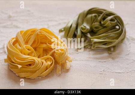 Vue rapprochée de la main italienne Pâtes Fettuccine organiques sur une planche en bois Banque D'Images