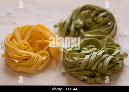 Vue rapprochée de la main italienne Pâtes Fettuccine organiques sur une planche en bois Banque D'Images