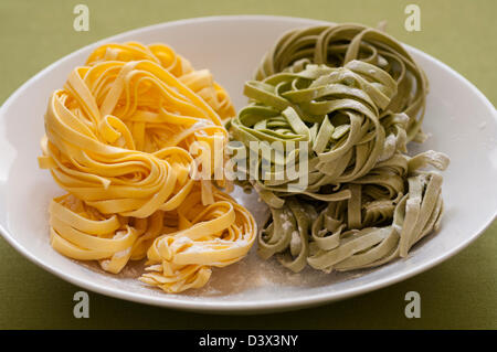 Vue rapprochée de la main italienne Pâtes Fettuccine organiques sur une planche en bois Banque D'Images