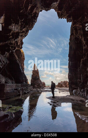Rocher de l'aiguille avec personne debout dans Plemont Grotte, Jersey, Channel Islands, Royaume-Uni Banque D'Images