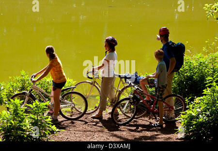 Groupe familial sur un vélo s'arrêter pour regarder un lac en plein soleil d'été Banque D'Images