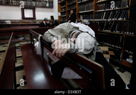 Le juif orthodoxe dort sur un banc dans une Yeshiva qui est une institution éducative juive qui se concentre sur l'étude des textes religieux traditionnels dans le quartier de MEA Shearim, une enclave ultra-orthodoxe dans Jérusalem-Ouest Israël Banque D'Images