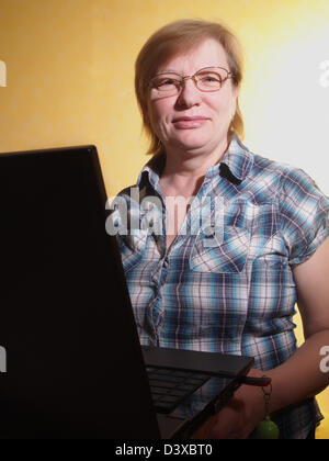 Femme d'âge moyen sur son ordinateur portable Banque D'Images
