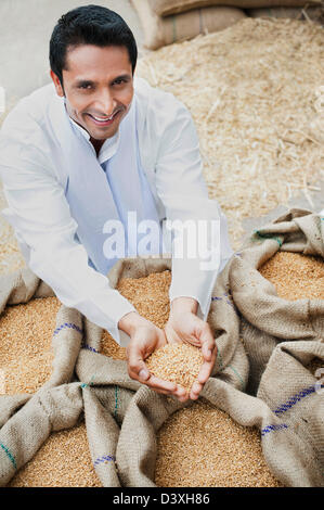 Homme tenant un sac de grains de blé dans son creux des mains, Anaj, Mandi, Sohna Gurgaon, Haryana, Inde Banque D'Images