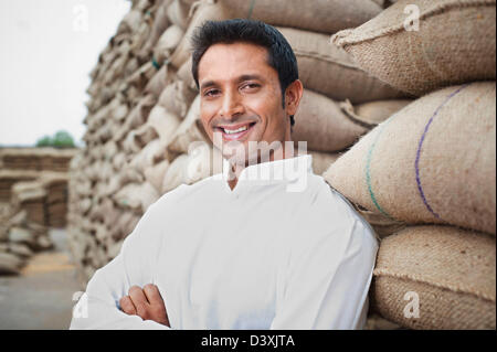 L'homme appuyé contre une pile de sacs de blé, Anaj, Mandi, Sohna Gurgaon, Haryana, Inde Banque D'Images