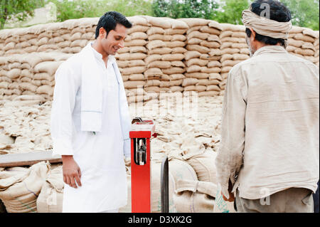 Homme sac de blé pesant sur une échelle, l'Anaj, Mandi, Sohna Gurgaon, Haryana, Inde Banque D'Images