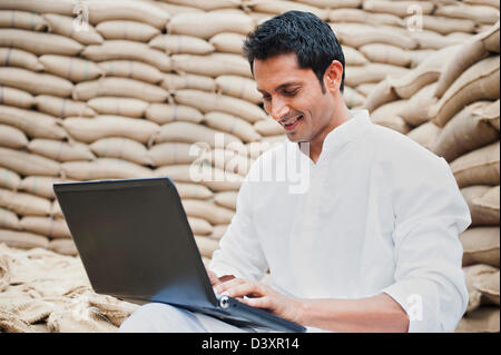 L'homme à l'aide d'un ordinateur portable dans un marché des céréales, l'Anaj, Mandi, Sohna Gurgaon, Haryana, Inde Banque D'Images