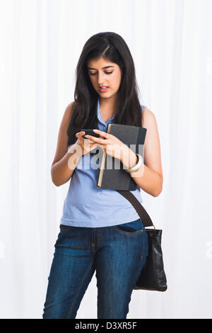 Teenage girl text messaging on a mobile phone Banque D'Images