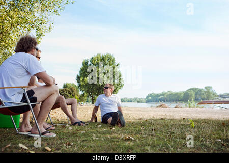 4 amis et d'avoir une bière au parc par Neckhar Rivière en Allemagne Banque D'Images