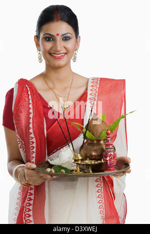 Femme tenant une puja Bengali thali Banque D'Images