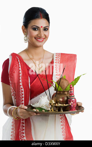 Femme tenant une puja Bengali thali Banque D'Images