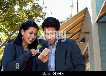 Mixed Race woman using cell phone outdoors Banque D'Images