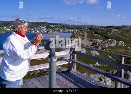 Femme regardant à travers un télescope au phare de Rose Blanche, Terre-Neuve et Labrador, Canada Banque D'Images