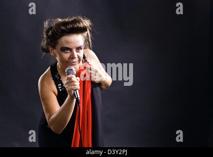 L'actrice en noir avec microphone et foulard rouge Banque D'Images