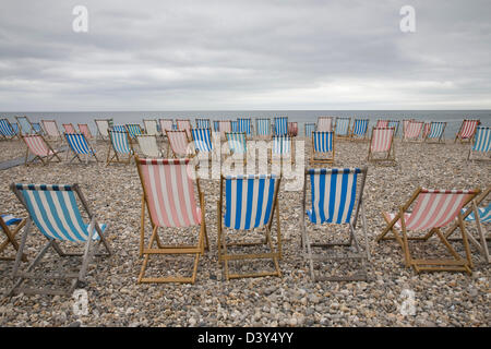 Un jour gris, transats sur la plage de bière vide dans le Devon. Banque D'Images