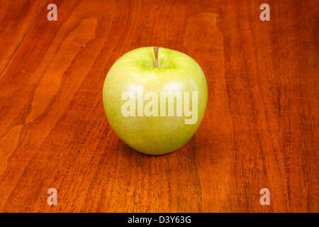 Un seul green Granny Smith apple sur une table en bois Banque D'Images