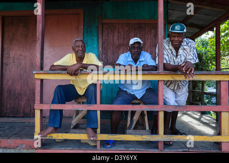 Trois hommes de Vieux Fort, ville St Lucia debout sur le porche d'une maison traditionnelle en bois Banque D'Images