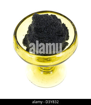 Un petit gobelet en verre fait main rempli de caviar noir sur fond blanc. Banque D'Images
