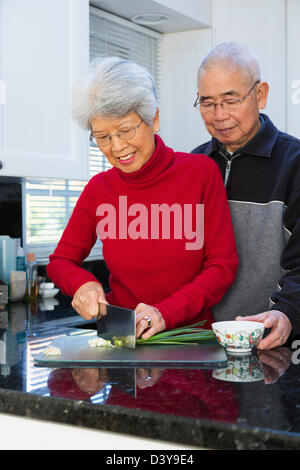 Couple chinois hacher des oignons dans la cuisine Banque D'Images